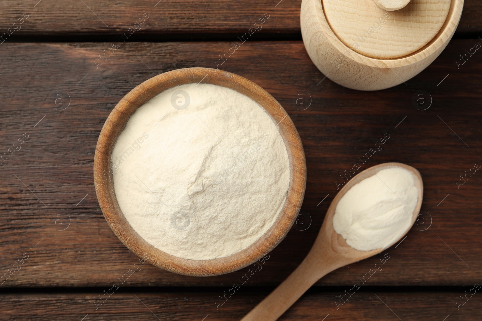 Photo of Bowl, box and spoon of agar-agar powder on wooden table, flat lay