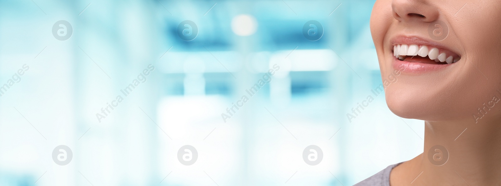 Image of Woman with clean teeth smiling on blurred background, closeup. Banner design with space for text