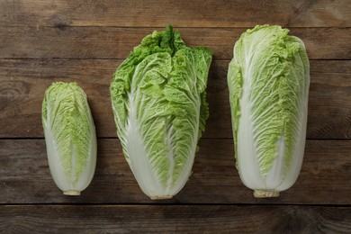 Photo of Fresh ripe Chinese cabbages on wooden table, fat lay