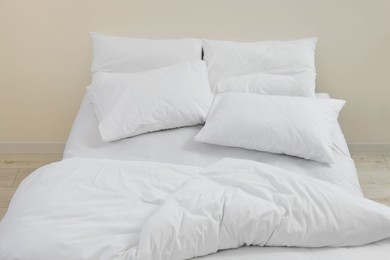 Photo of White soft pillows on cozy bed in room