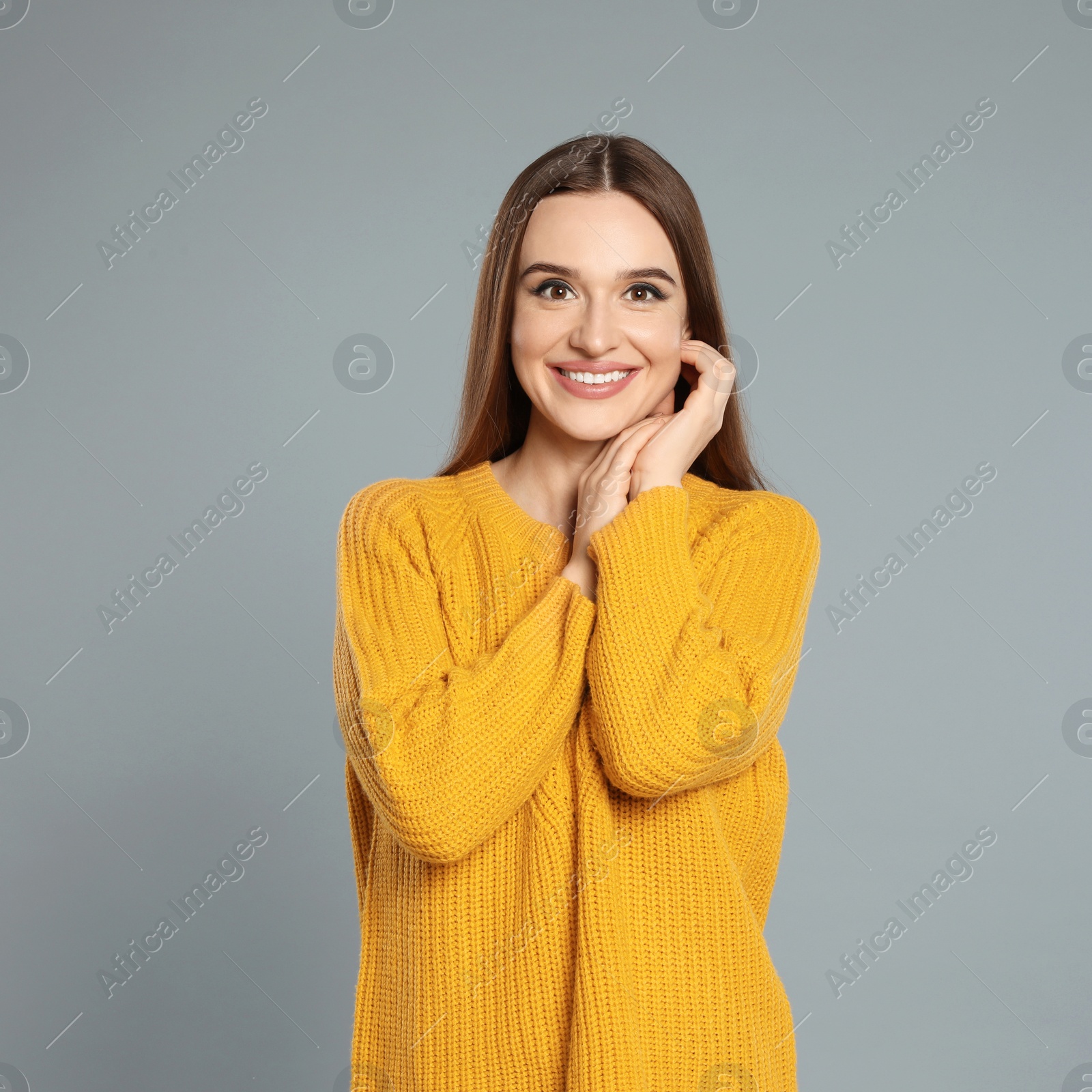 Photo of Beautiful young woman in yellow sweater on grey background. Winter season