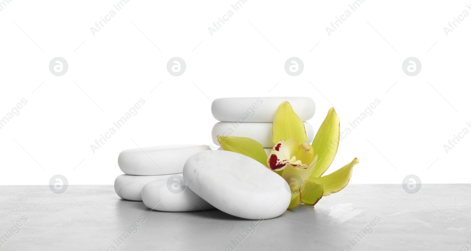 Photo of Orchid flower with spa stones on white background