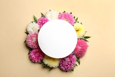 Photo of Flat lay composition with blank card and beautiful asters on beige background, space for text. Autumn flowers
