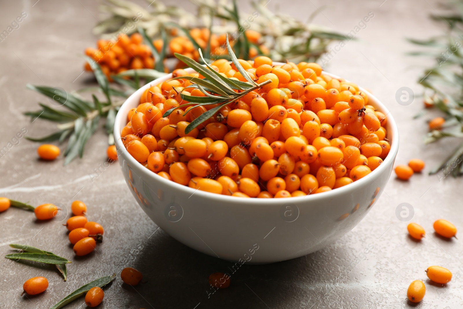 Photo of Ripe sea buckthorn berries on marble table, closeup