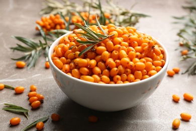 Photo of Ripe sea buckthorn berries on marble table, closeup