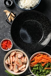 Photo of Flat lay composition with black wok and products on dark textured table