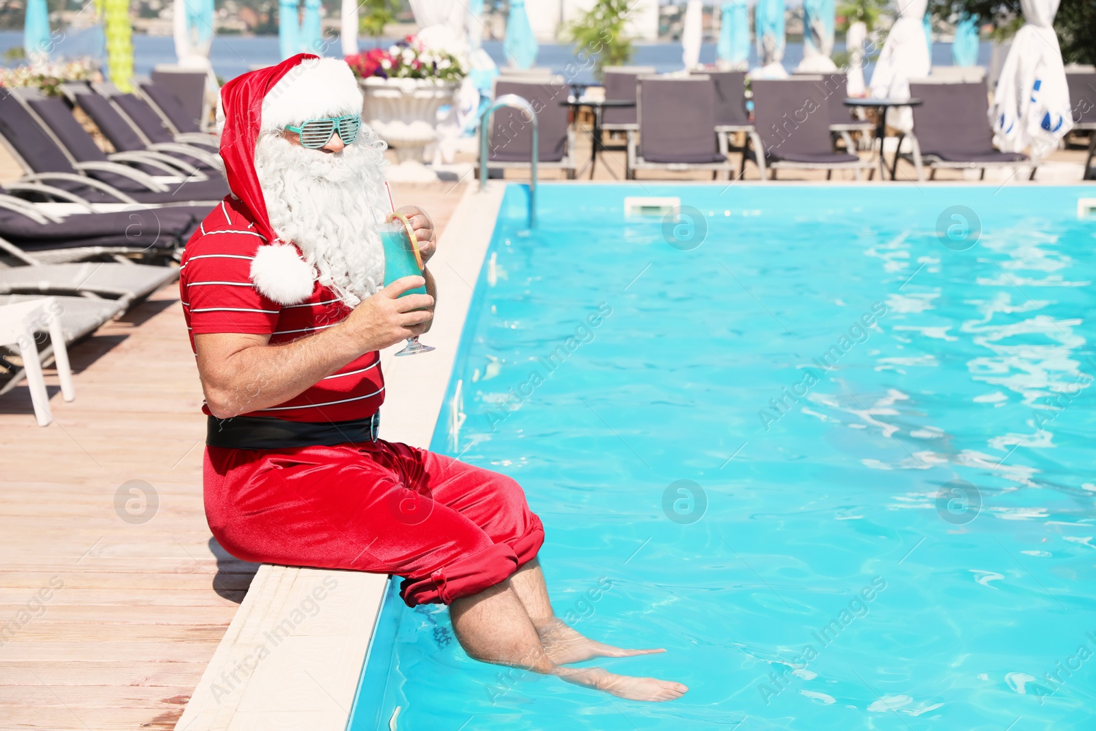 Photo of Authentic Santa Claus with cocktail near pool at resort