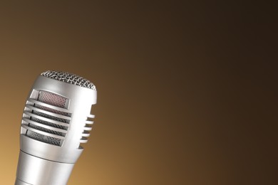 Photo of Sound recording and reinforcement. Microphone on light brown background, closeup. Space for text