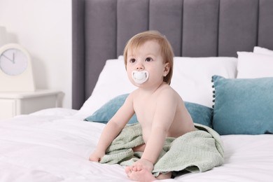 Photo of Cute little baby with towel after bathing on bed