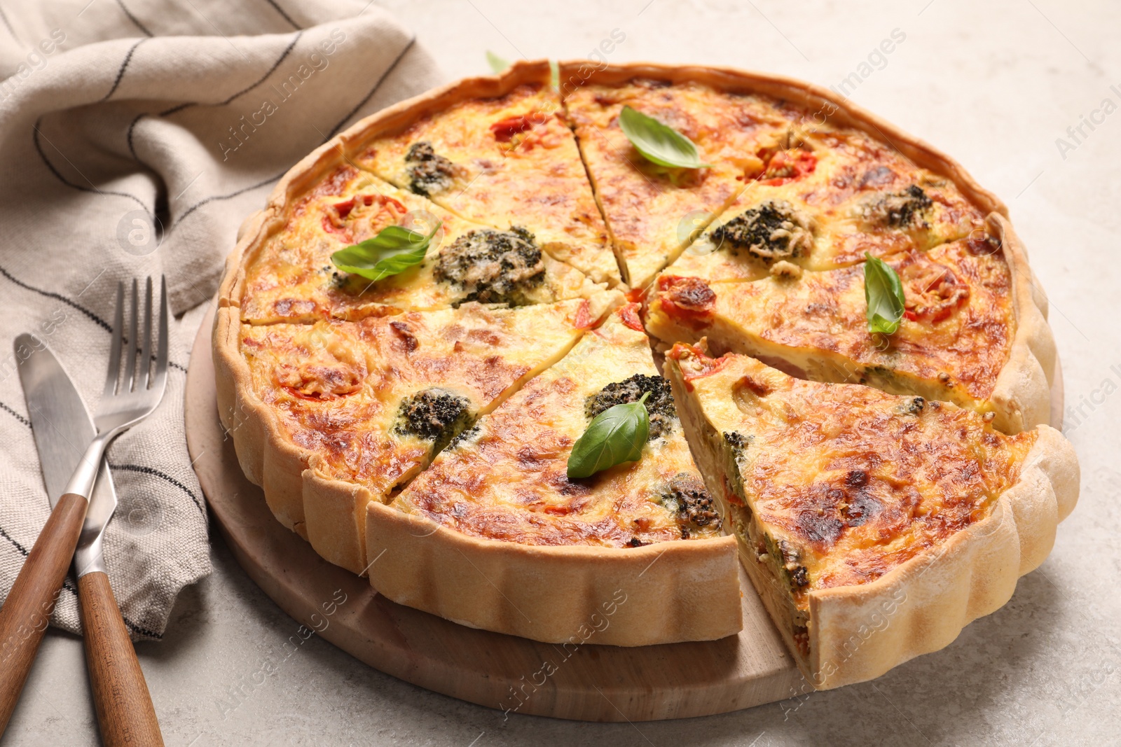 Photo of Delicious homemade vegetable quiche and cutlery on table