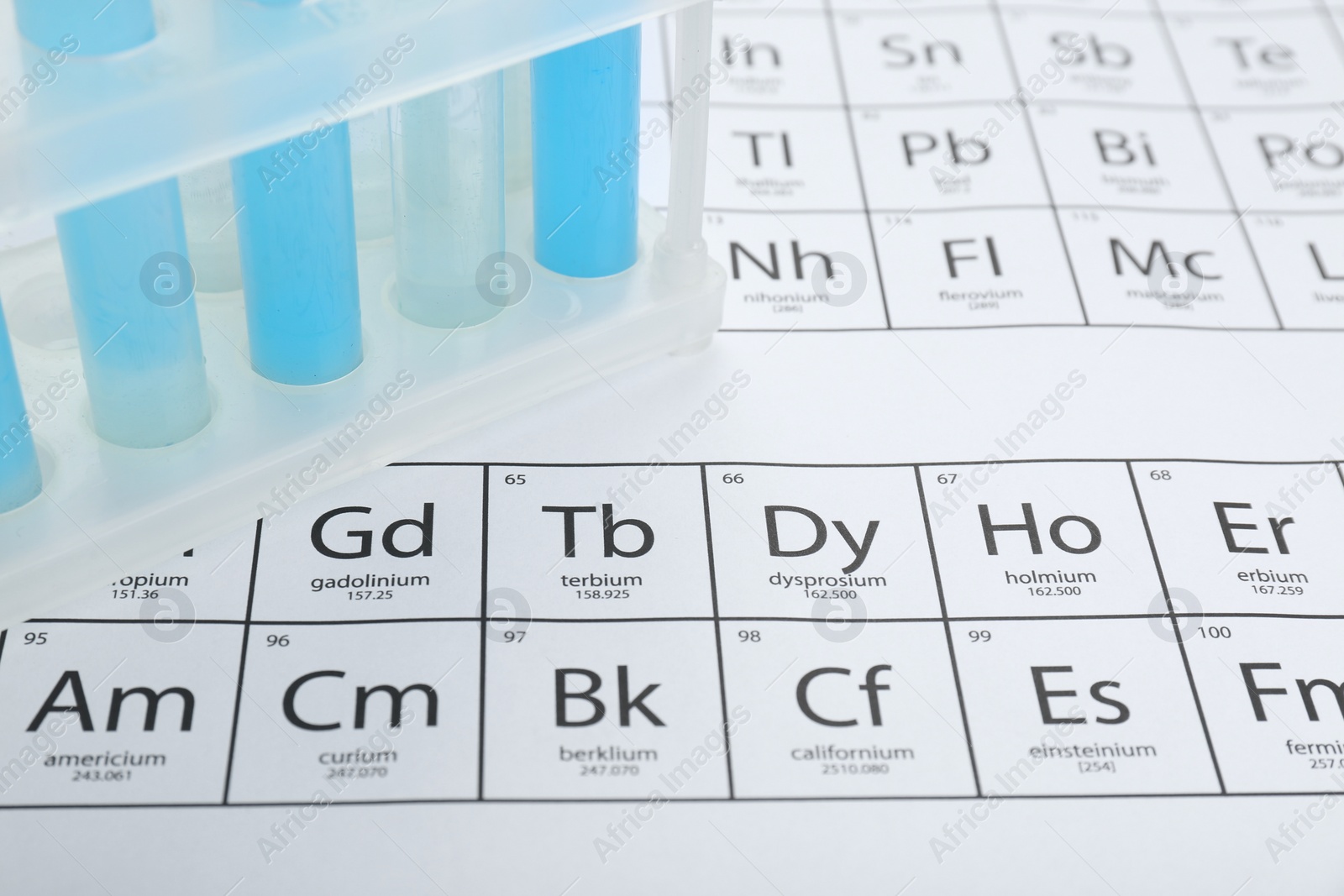 Photo of Test tubes in rack on periodic table of chemical elements, closeup