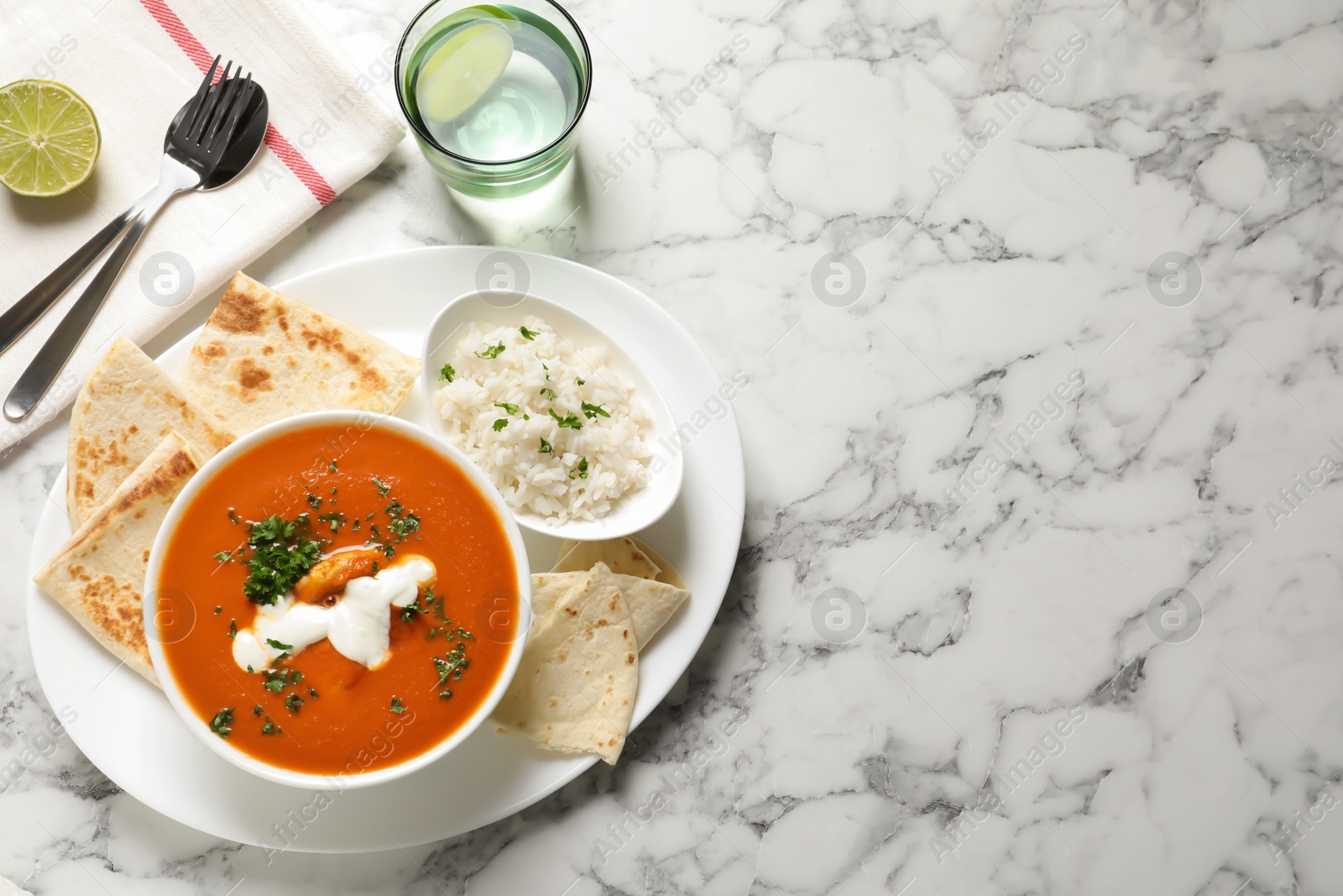 Photo of Delicious butter chicken served on marble table, top view with space for text. Traditional Murgh Makhani dish