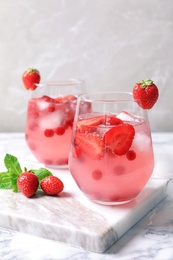 Photo of Glasses of natural lemonade with berries on table