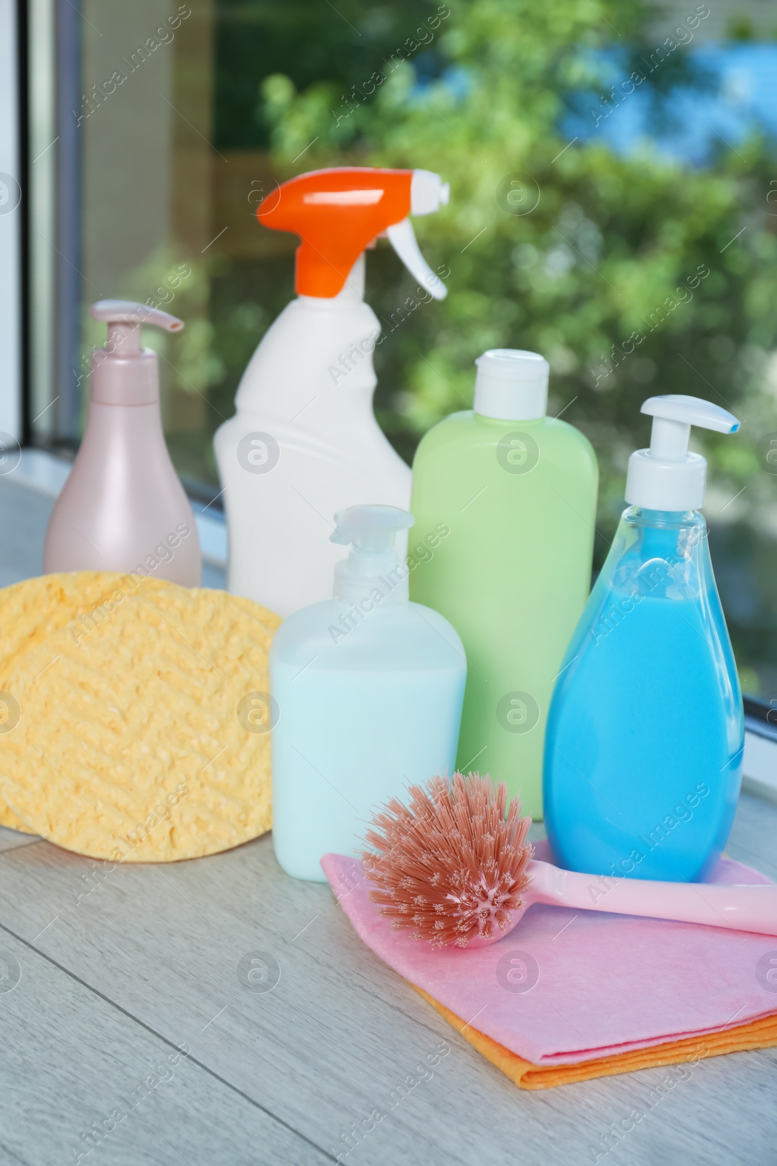 Photo of Different cleaning supplies and tools on window sill indoors