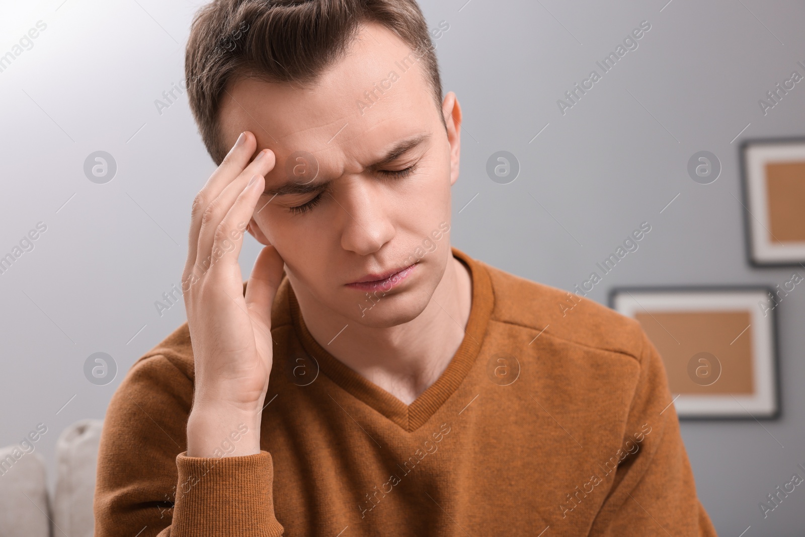 Photo of Sad man suffering from headache at home