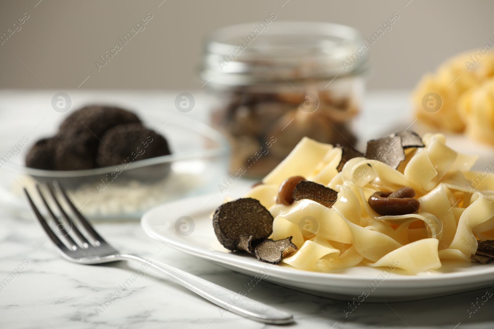 Photo of Tasty tagliatelle with truffle on white marble table, closeup