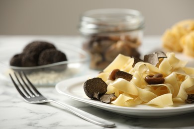 Tasty tagliatelle with truffle on white marble table, closeup