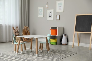 Photo of Child's room interior with stylish table, chairs and toys