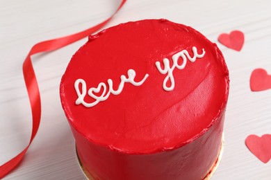 Bento cake with text Love You and paper hearts on white wooden table, closeup. St. Valentine's day surprise