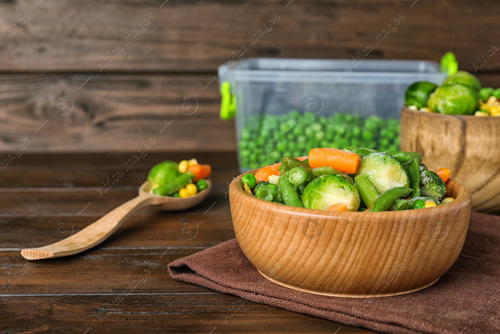 Photo of Bowl with different frozen vegetables on wooden table