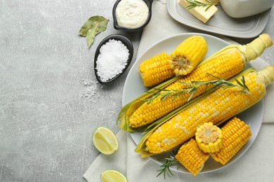 Photo of Flat lay composition with tasty boiled corn on light grey table. Space for text