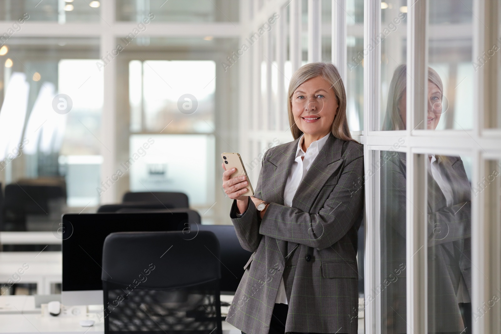 Photo of Smiling woman with smartphone in office, space for text. Lawyer, businesswoman, accountant or manager