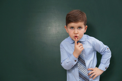 Cute little child near chalkboard, space for text. First time at school