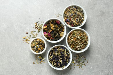 Photo of Flat lay composition with different dry teas on light grey table