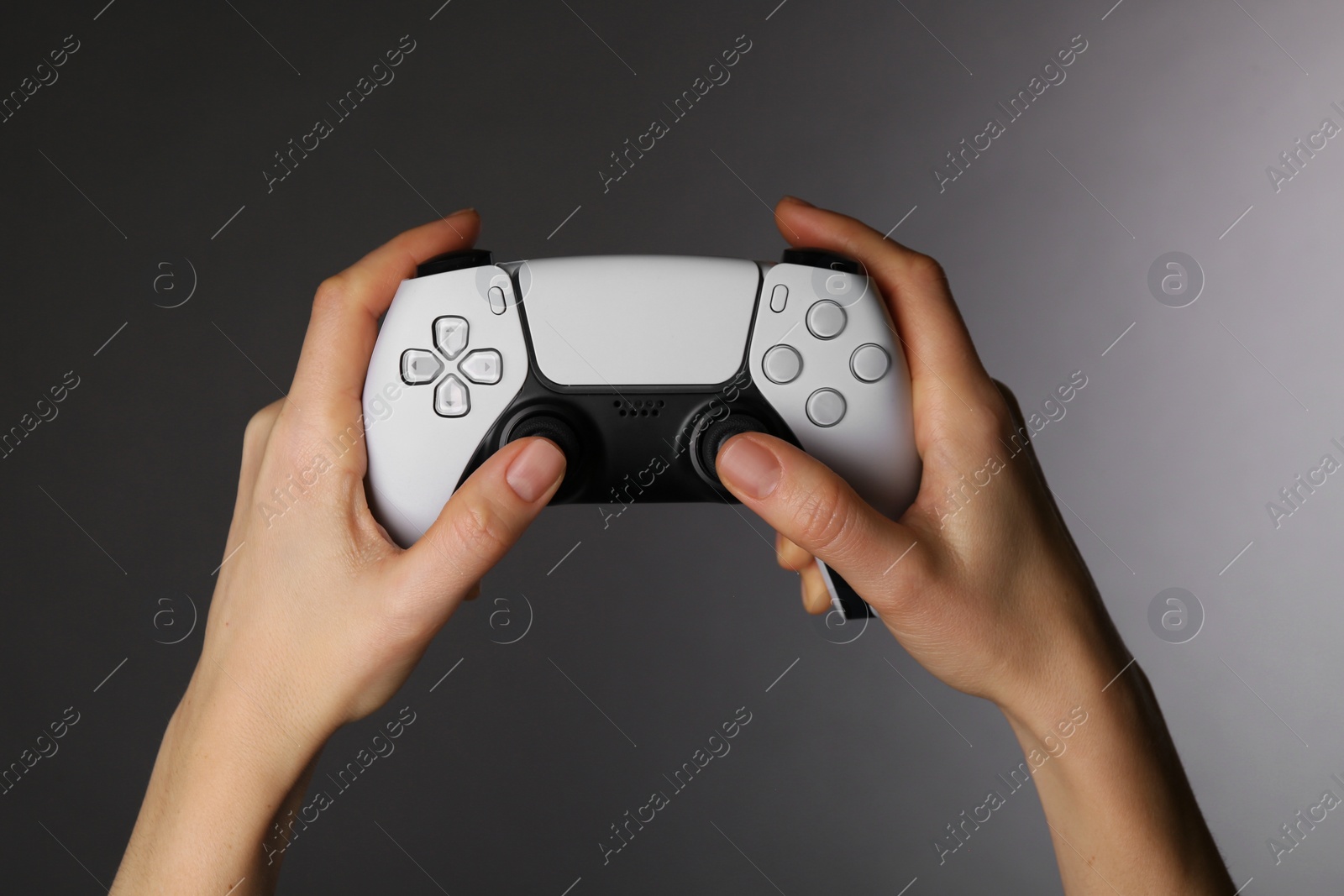 Photo of Woman using game controller on grey background, closeup