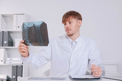 Photo of Doctor examining neck MRI image in clinic