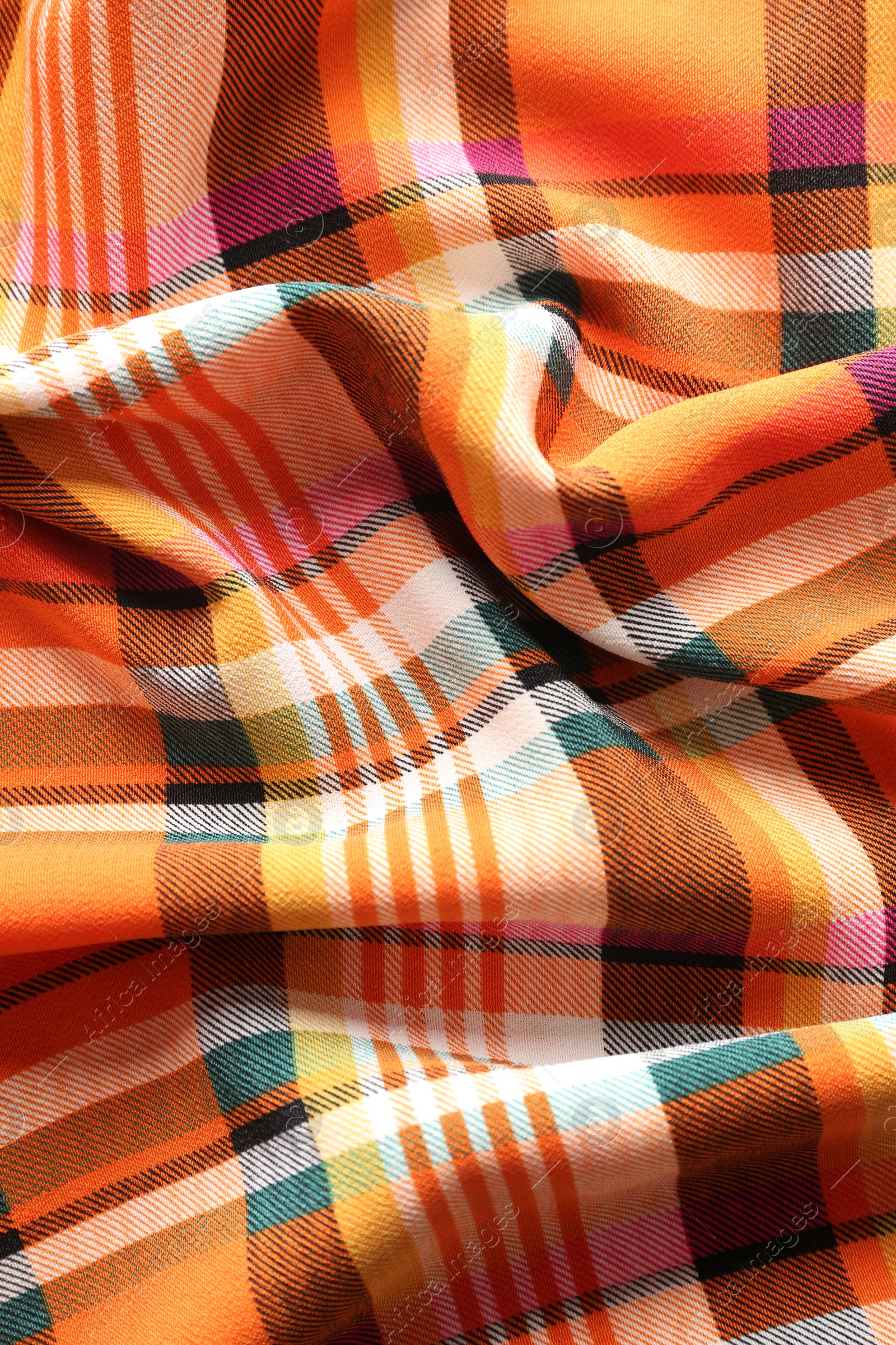 Photo of Checkered fabric with orange color as background, top view