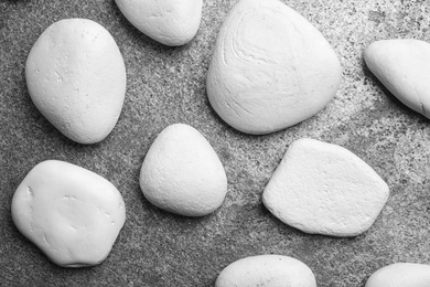 Zen stones on grey background, top view