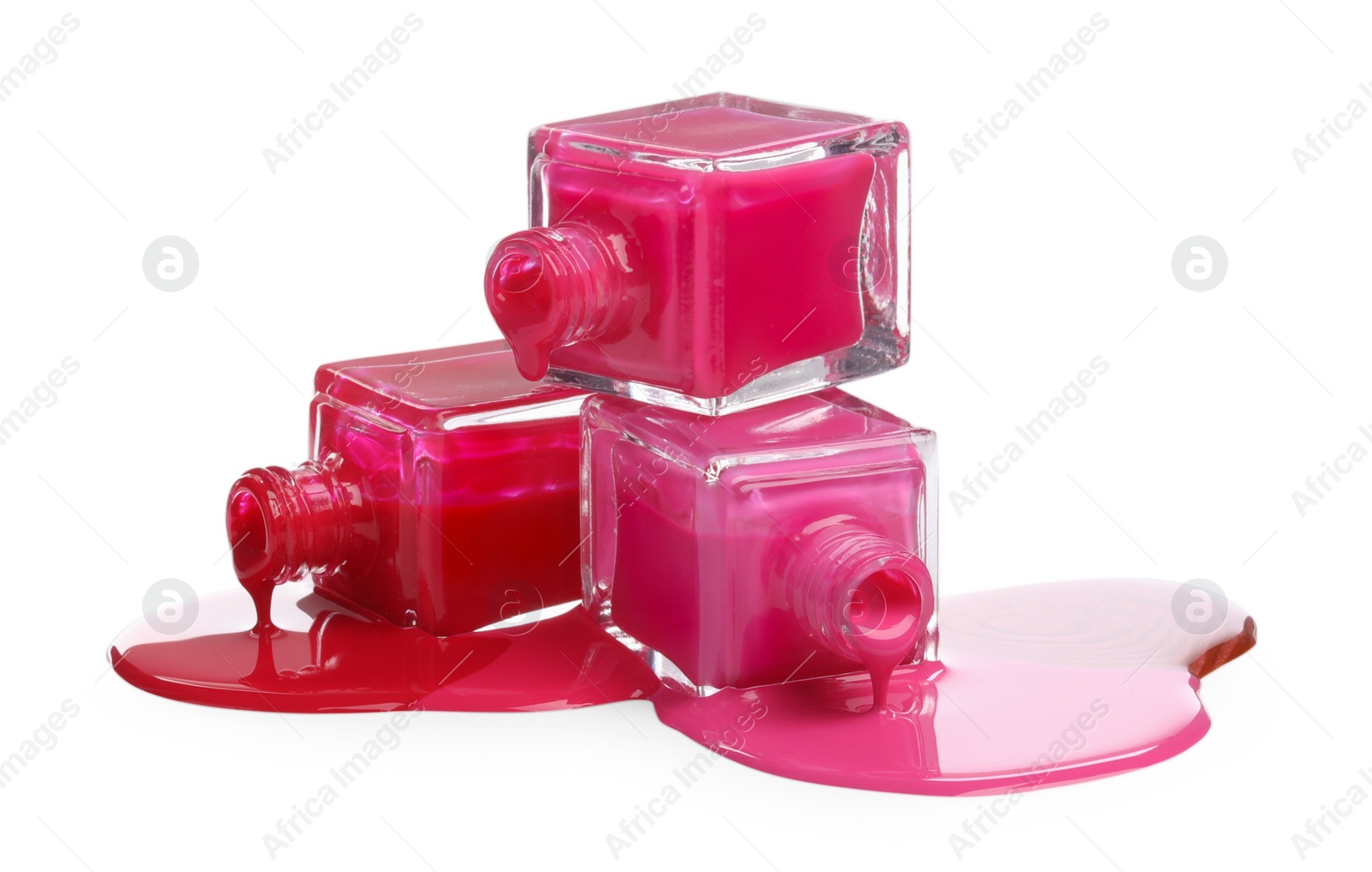 Photo of Color nail polishes dripping from bottles isolated on white