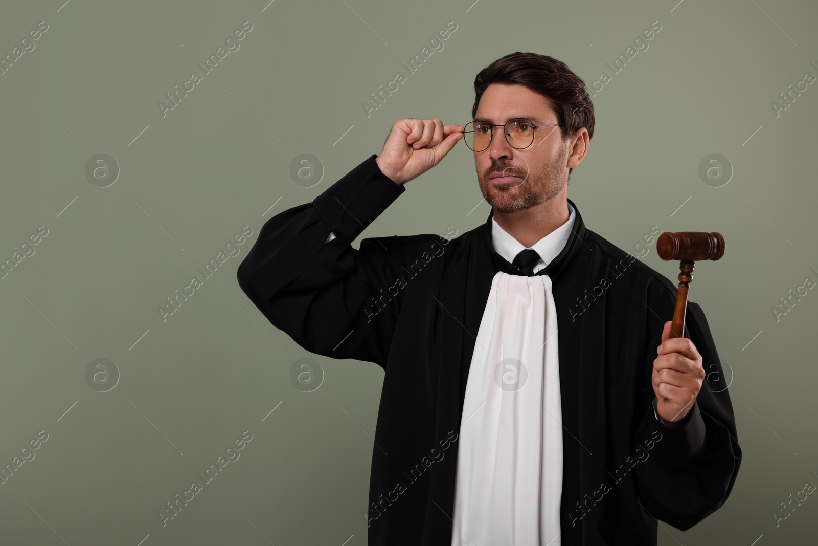 Photo of Judge with gavel on green background. Space for text
