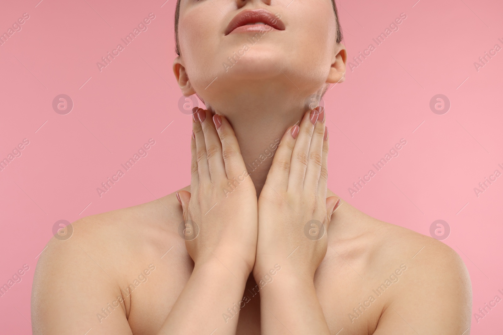 Photo of Woman touching her neck on pink background, closeup