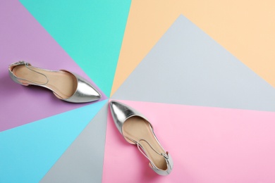 Pair of female shoes on color background, top view