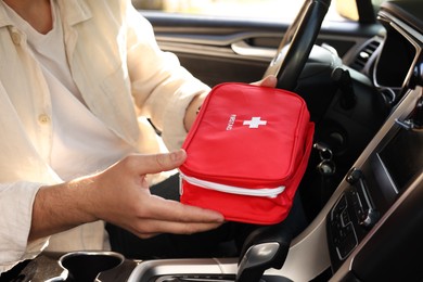 Photo of Man with first aid kit inside car, closeup