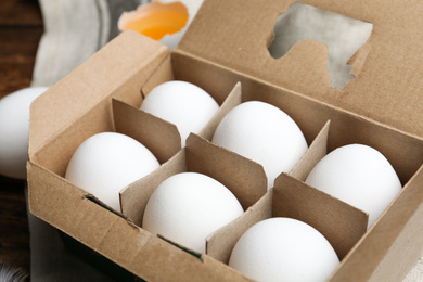 Photo of Fresh raw chicken eggs in box on table, closeup