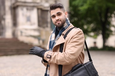 Smiling man in warm scarf on city street