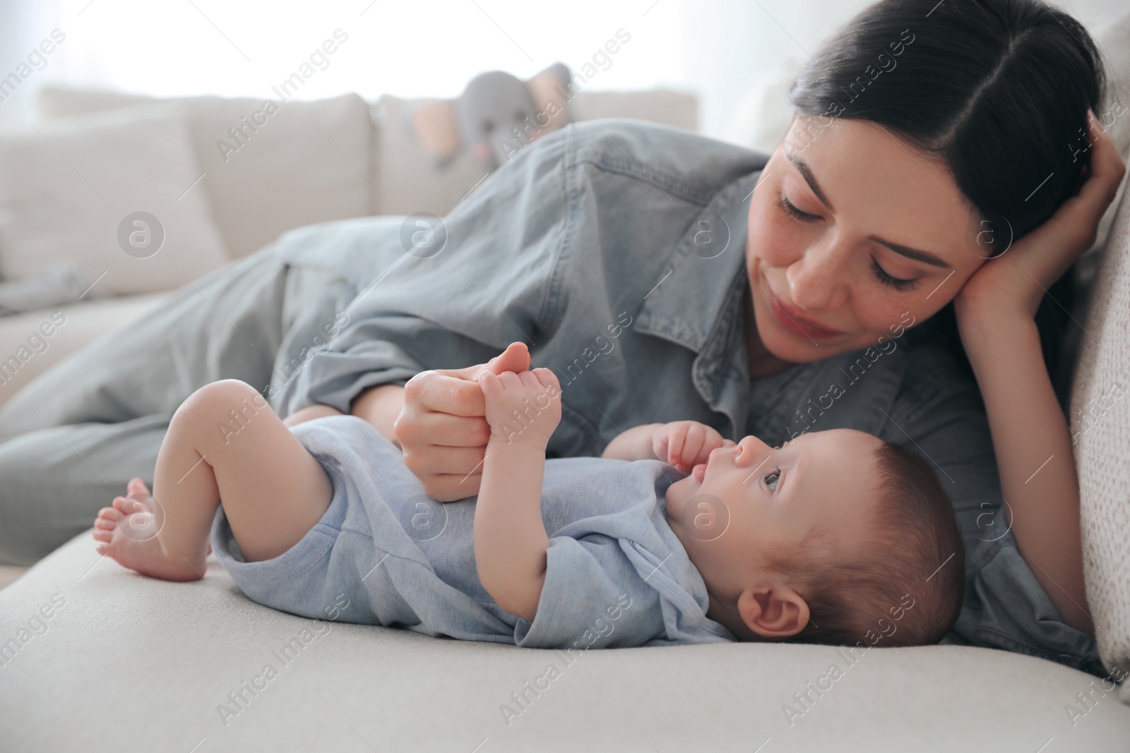 Photo of Happy family with cute baby on sofa at home