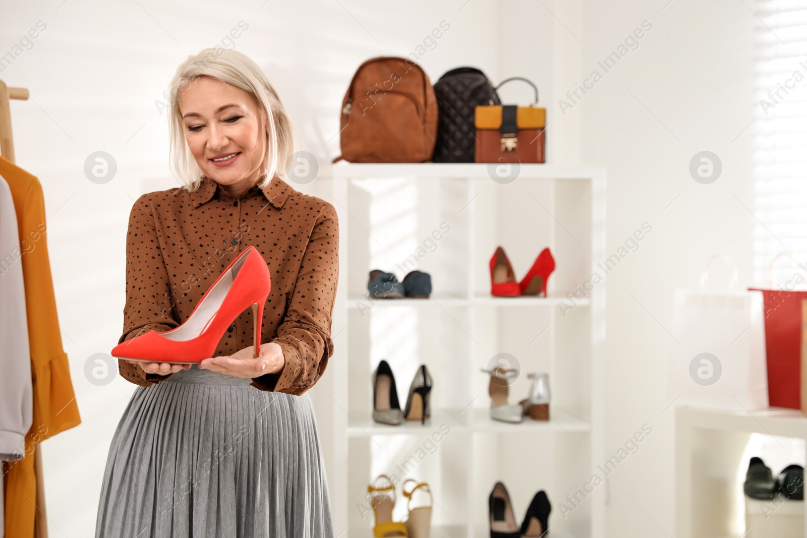 Photo of Female business owner showing shoe in boutique. Space for text