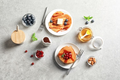 Flat lay composition with tasty pancakes on grey background