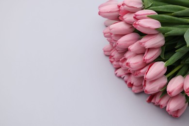 Bouquet of beautiful pink tulips on light grey background, above view. Space for text