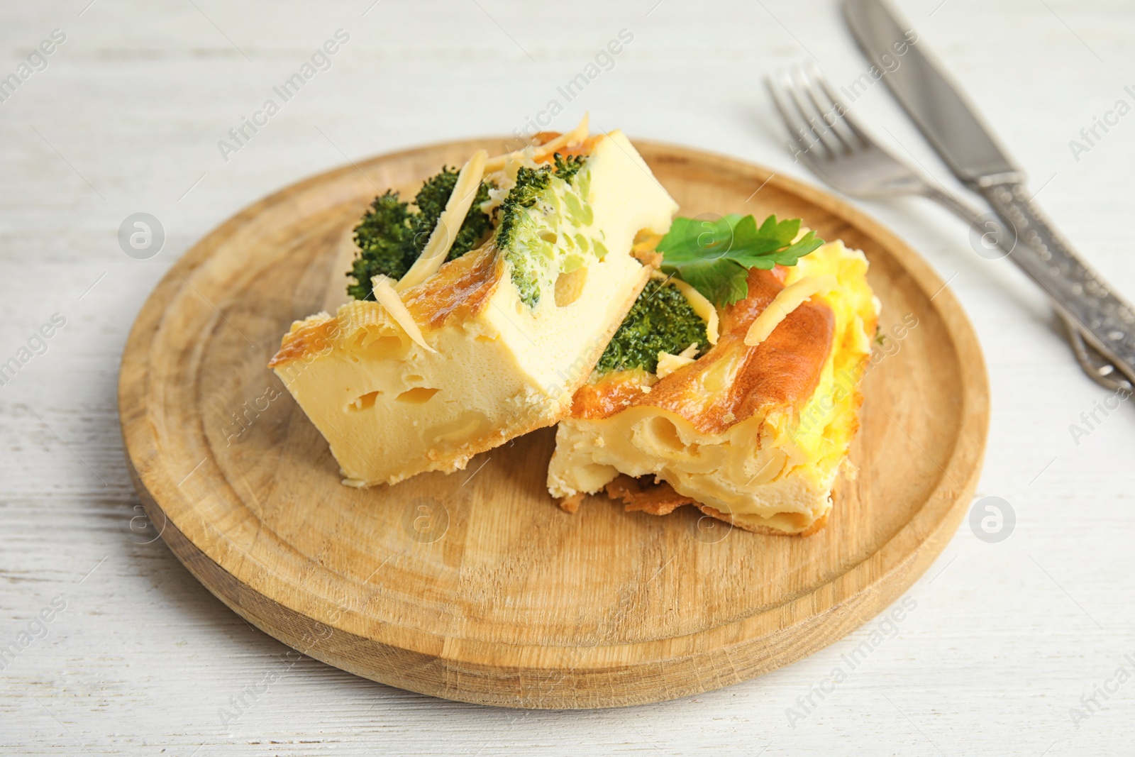 Photo of Tasty broccoli casserole served on white wooden table