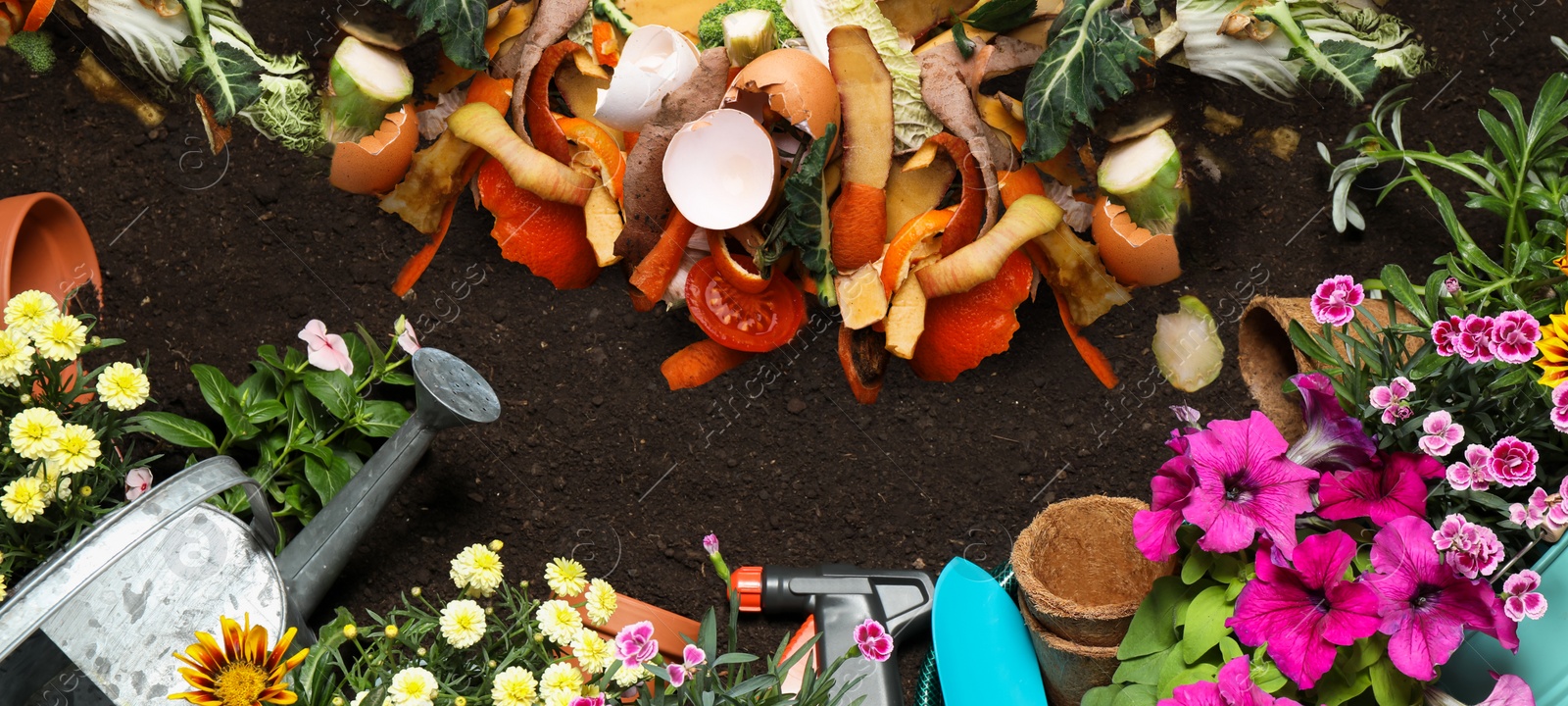 Image of Gardening tools, flowers and organic waste for composting on soil, flat lay. Natural fertilizer