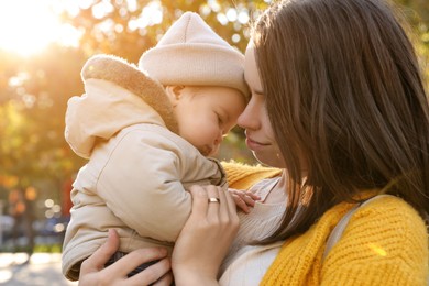 Photo of Happy mother with her baby son outdoors on autumn day