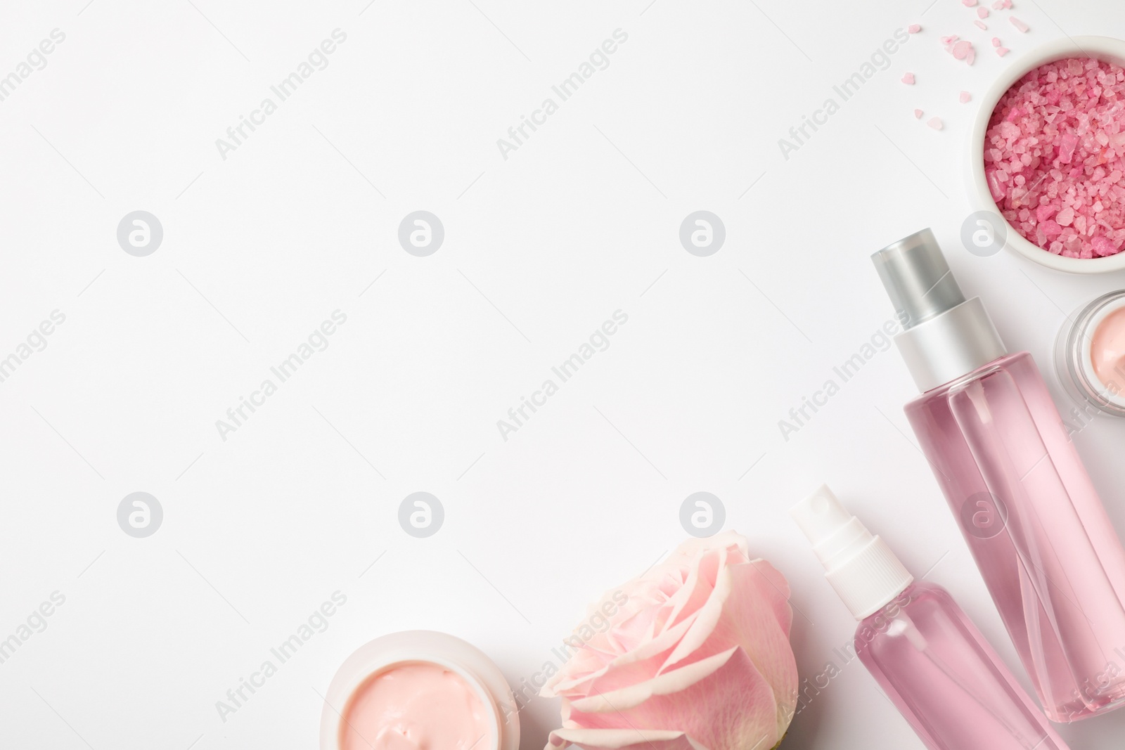 Photo of Composition with rose essential oil on white background, top view. Space for text