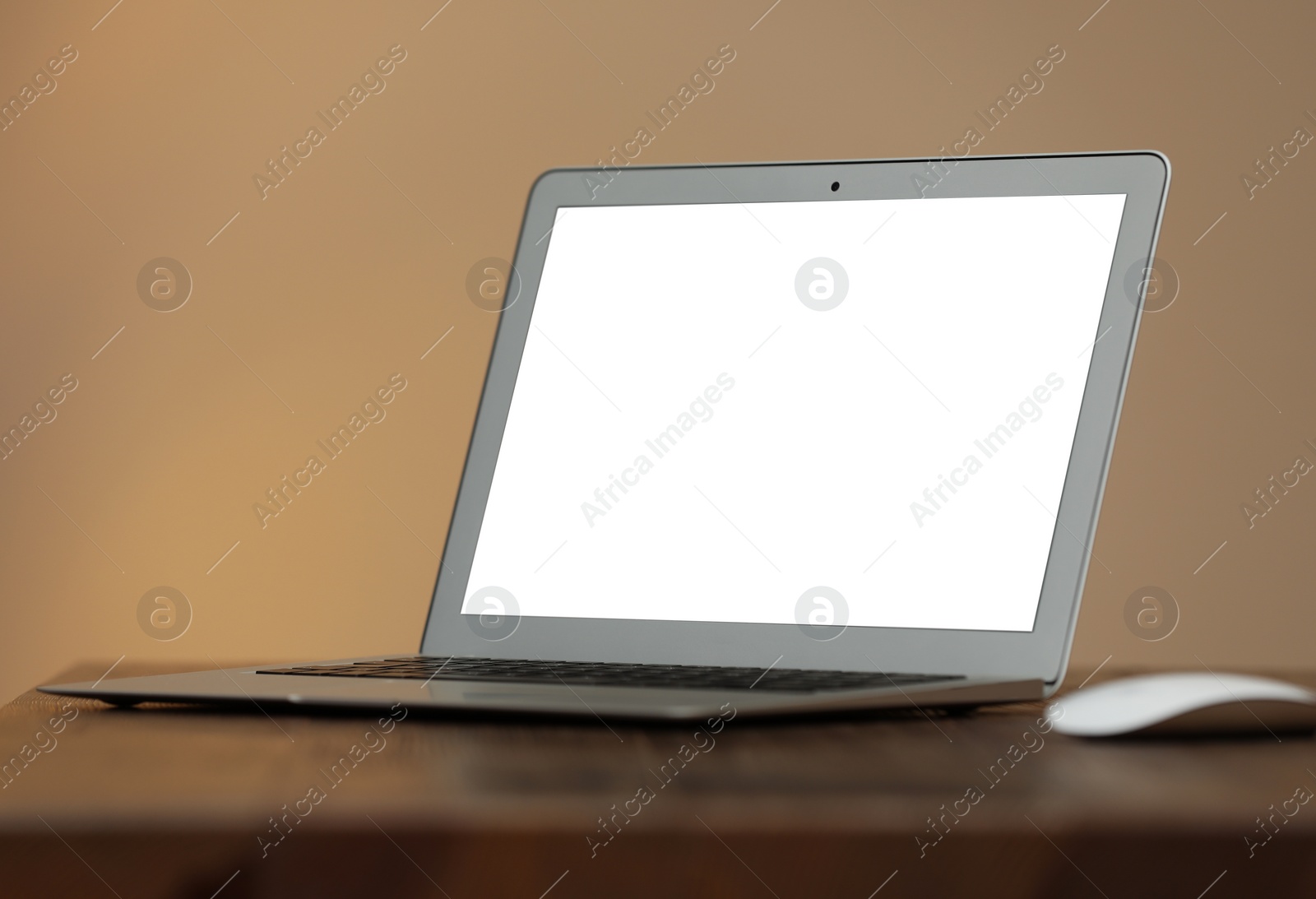 Photo of Laptop with blank screen on table indoors. Space for text