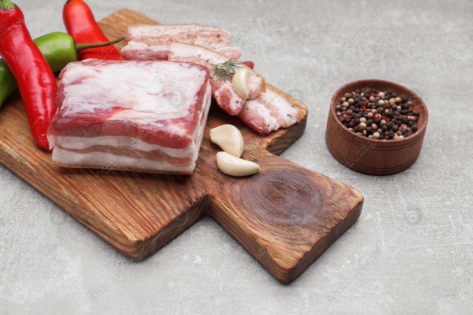 Photo of Tasty pork fatback with spices on grey table, closeup