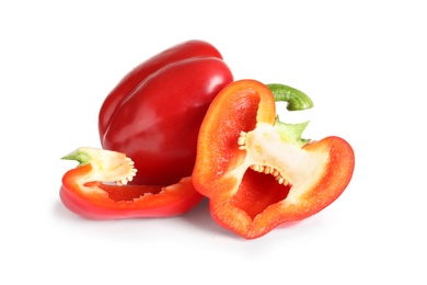 Cut and whole ripe red bell peppers on white background